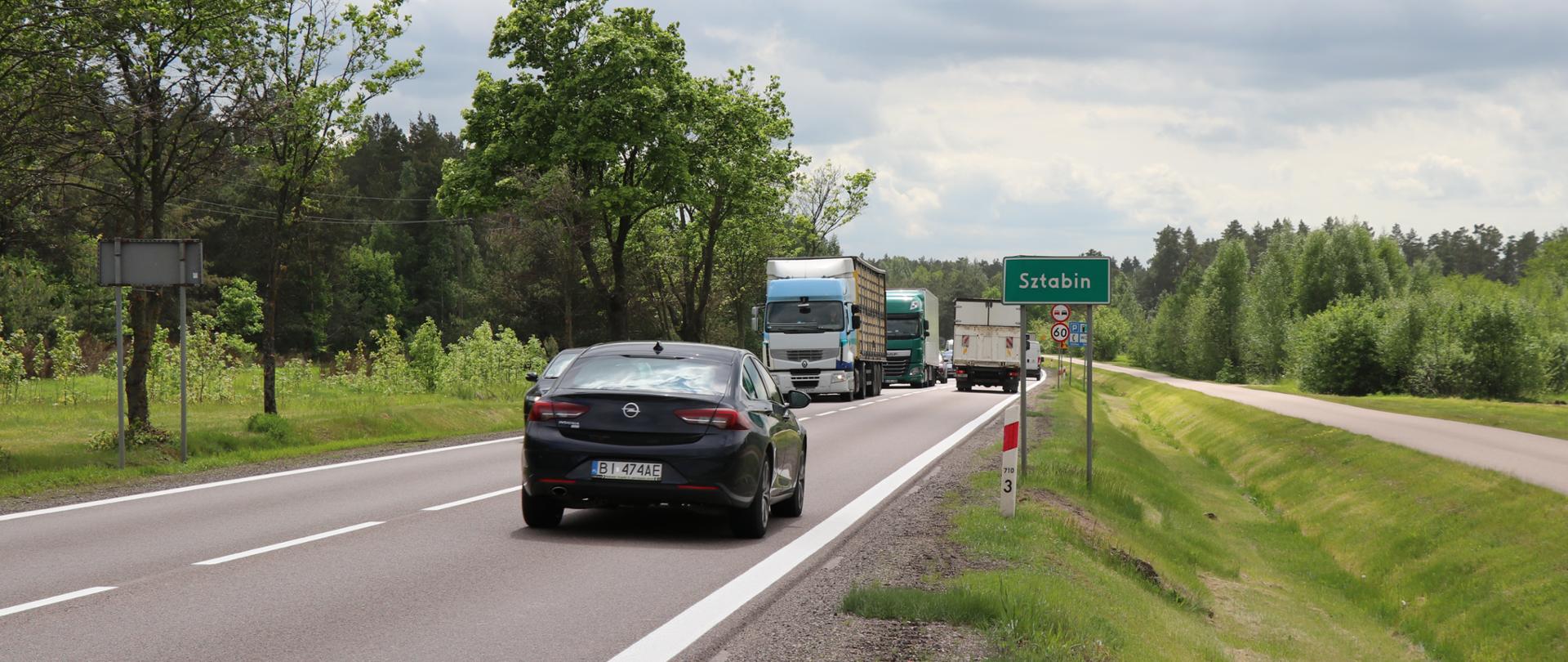 Zatłoczona droga, auta osobowe i ciężarowe jada w przeciwnych kierunkach 