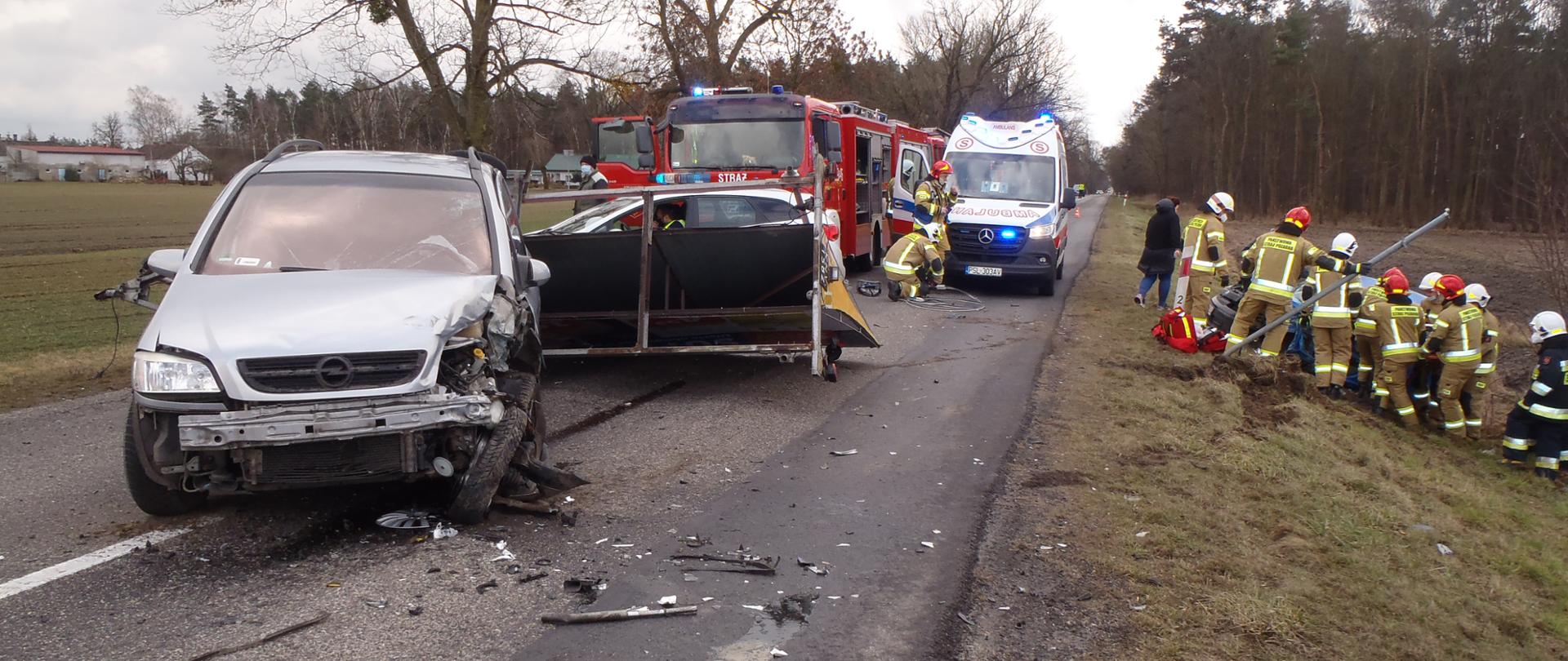 Samochód osobowy z przyczepą blokuje drogę Strażacy uwalniają osbę z drugiego samochodu