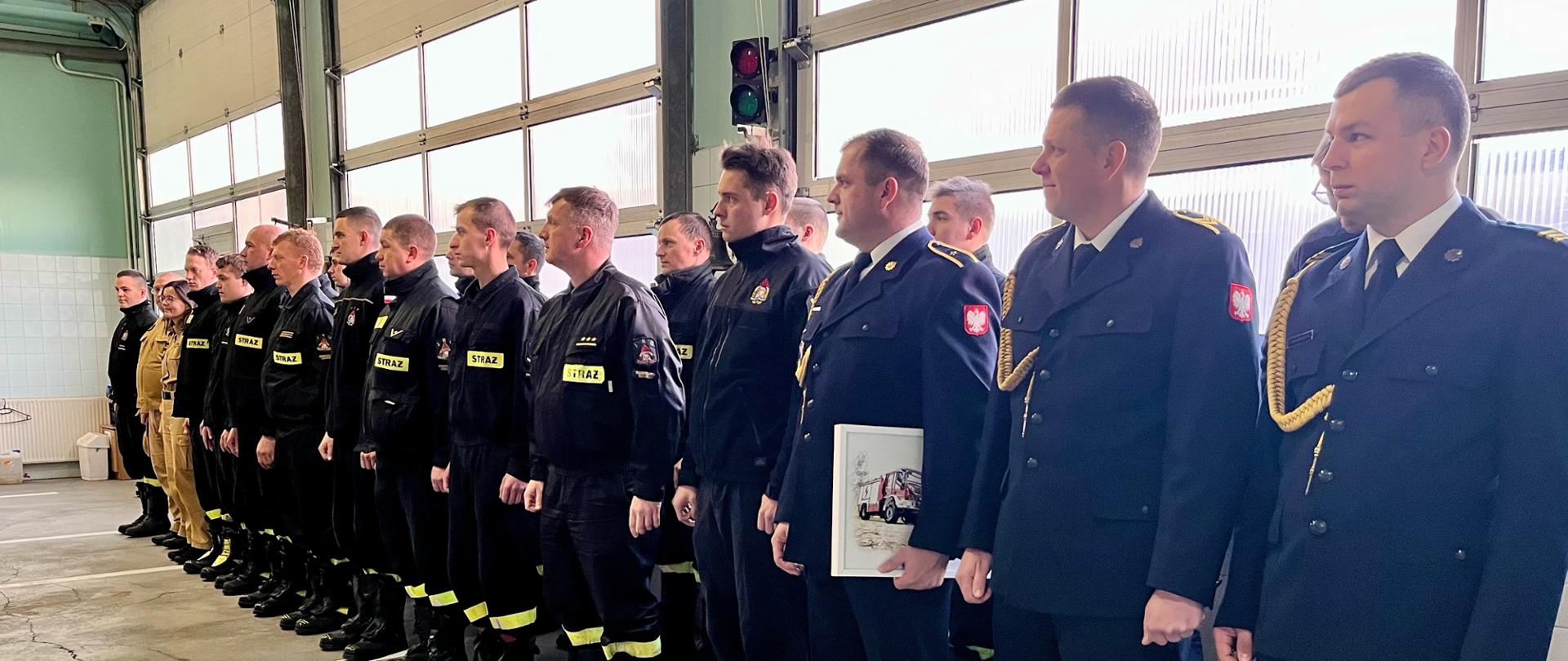 Zmiana służbowa i wyróżnieni funkcjonariusze ustawieni w szeregu