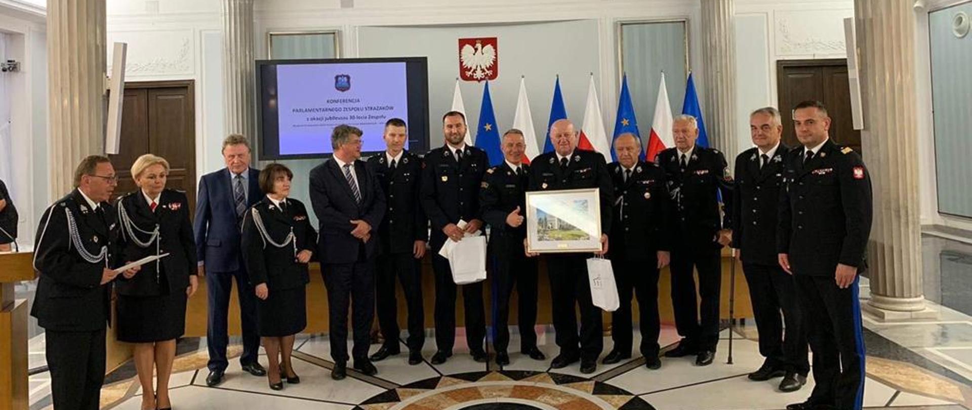 20 czerwca br. w gmachu Sejmu Rzeczpospolitej Polskiej odbyła się uroczysta konferencja pod honorowym patronatem Pana Mariusza Kamińskiego, Ministra Spraw Wewnętrznych i Administracji, z okazji jubileuszu 30-lecia Parlamentarnego Zespołu Strażaków. W konferencji udział więli: sekretarz stanu w Ministerstwie Spraw Wewnętrzych i Administracji - Pan Maciej Wąsik - oraz komendant główny Państwowej Straży Pożarnej - gen. brygadier Andrzej Bartkowiak - wraz z zastępcami i kadrą kierowniczą PSP.