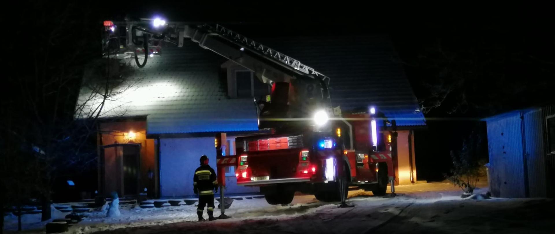 Zdjęcie przedstawia rozstawiony podnośnik hydrauliczny SHD-23 obok budynku mieszkalnego.