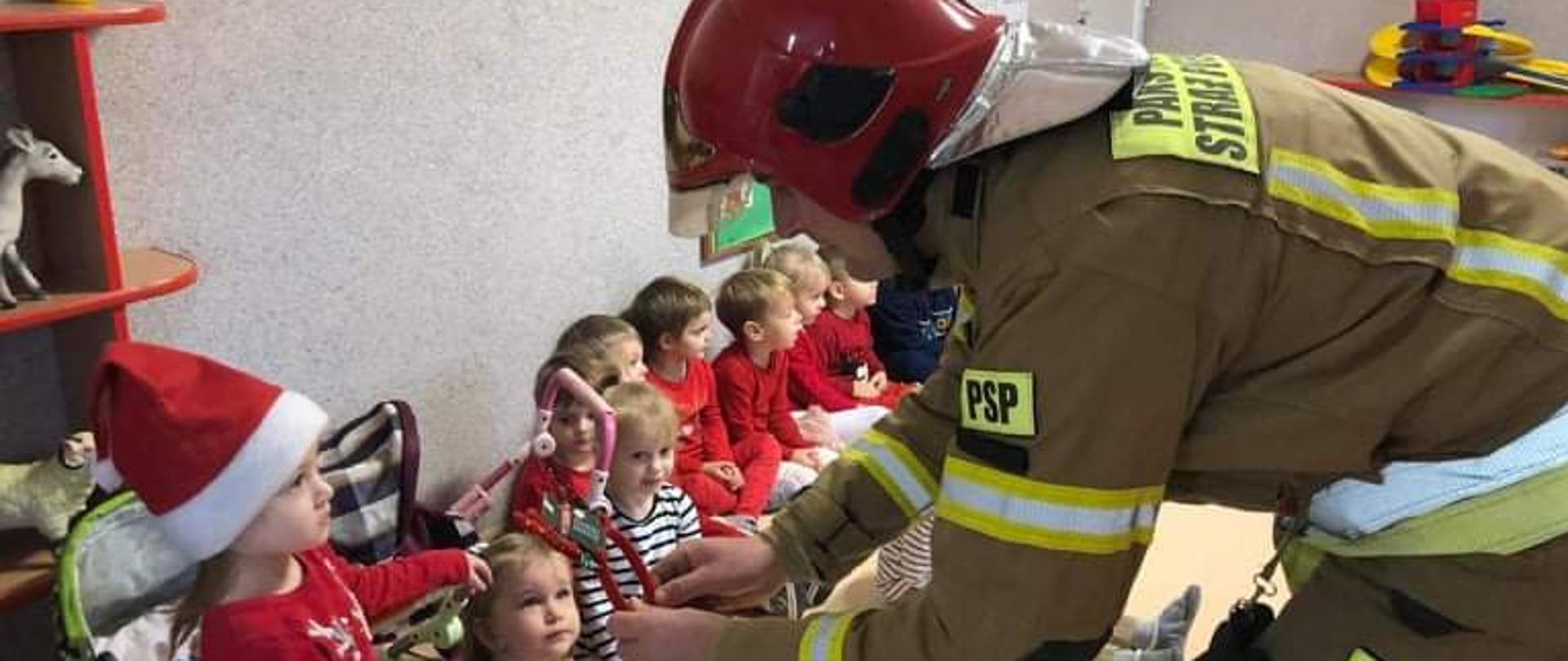 Strażak wręcza prezenty dzieciom w przedszkolu