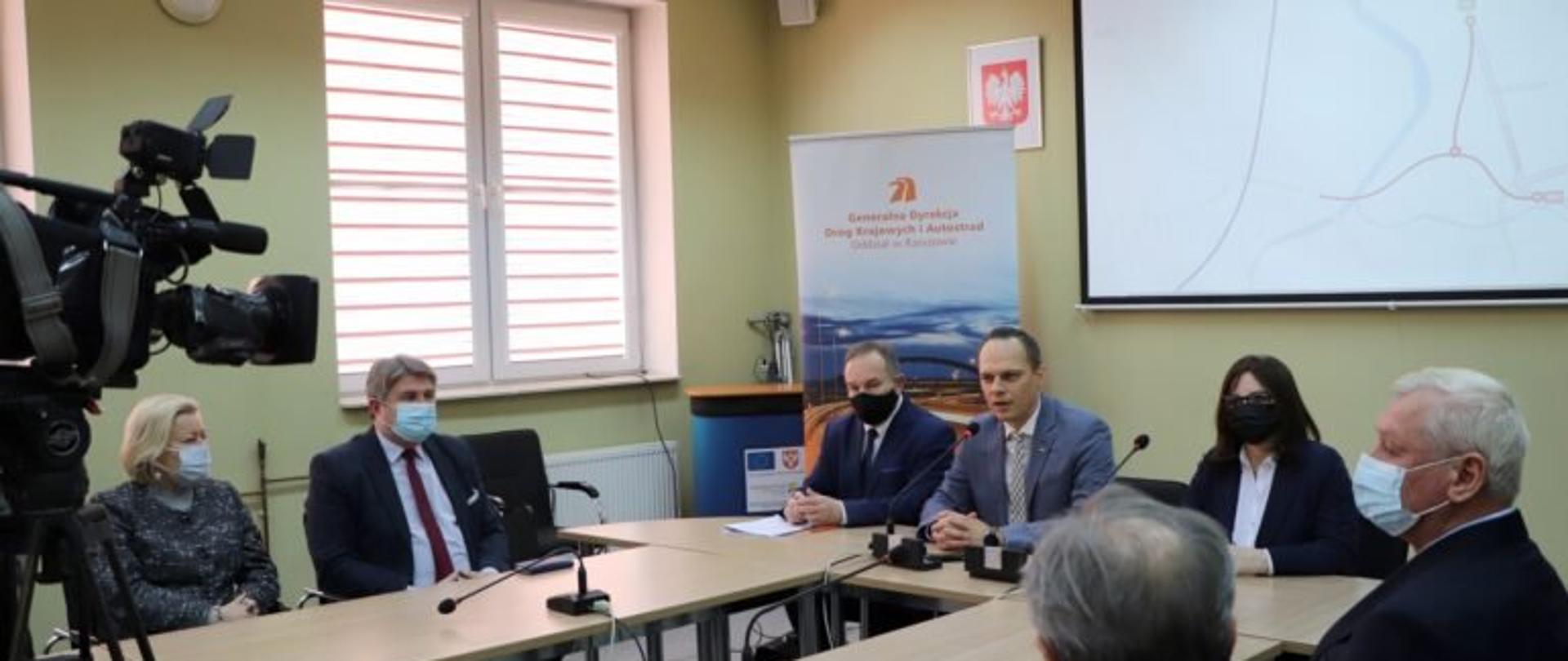 Wiceminister infrastruktury Rafał Weber zabiera głos podczas konferencji dotyczącej rozpoczęcia prac projektowych obwodnicy Jasła. Po prawej stronie siedzi wicewojewoda podkarpacki Jolanta Sawicka, po lewej dyrektor Oddziału Regionalnego Generalnej Dyrekcji Dróg Krajowych i Autostrad w Rzeszowie Bogdan Tarnawski.