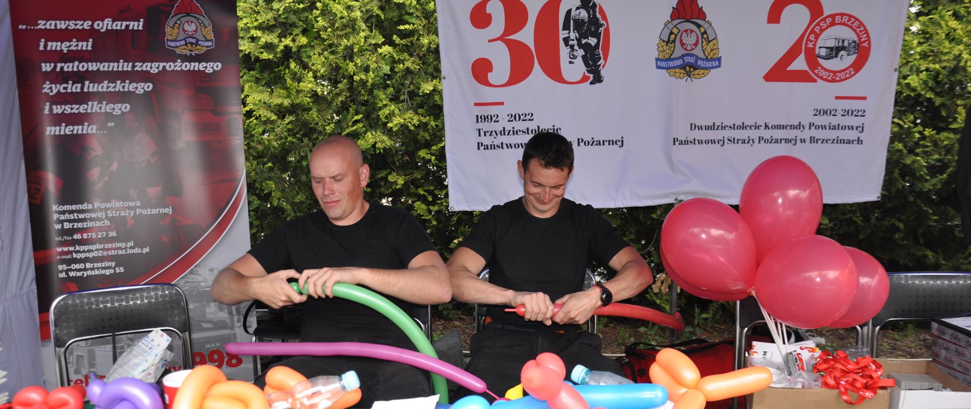 Strażacy wykonują maskotki z balonów dla dzieci.