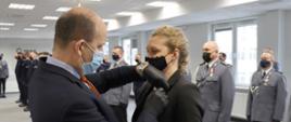 Wojewoda Mazowiecki Konstanty Radziwiłł wręcza Medal za Długoletnią Służbę zasłużonej policjantce.