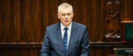 Minister Tomasz Siemoniak przemawia przed mównicą sejmową. 