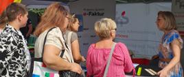 Kobiety zebrane przy stoisku informacyjnym o KSeF podczas Podlaskiego Święta Chleba
