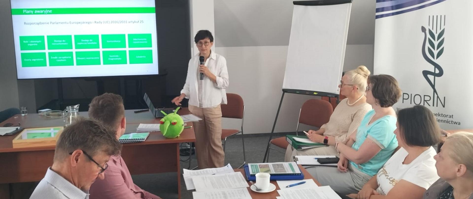 Na sali konferencyjnej maskotka Pesty wraz inspektorami WIORiN w Kielcach uczestniczy w wykładzie Pani ekspert z Instytutu Ochrony Roślin Państwowego Instytutu Badawczego w Poznaniu