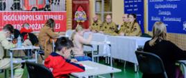 Dzieci piszą test wiedzy na turnieju pod okiem komisji egzaminacyjnej