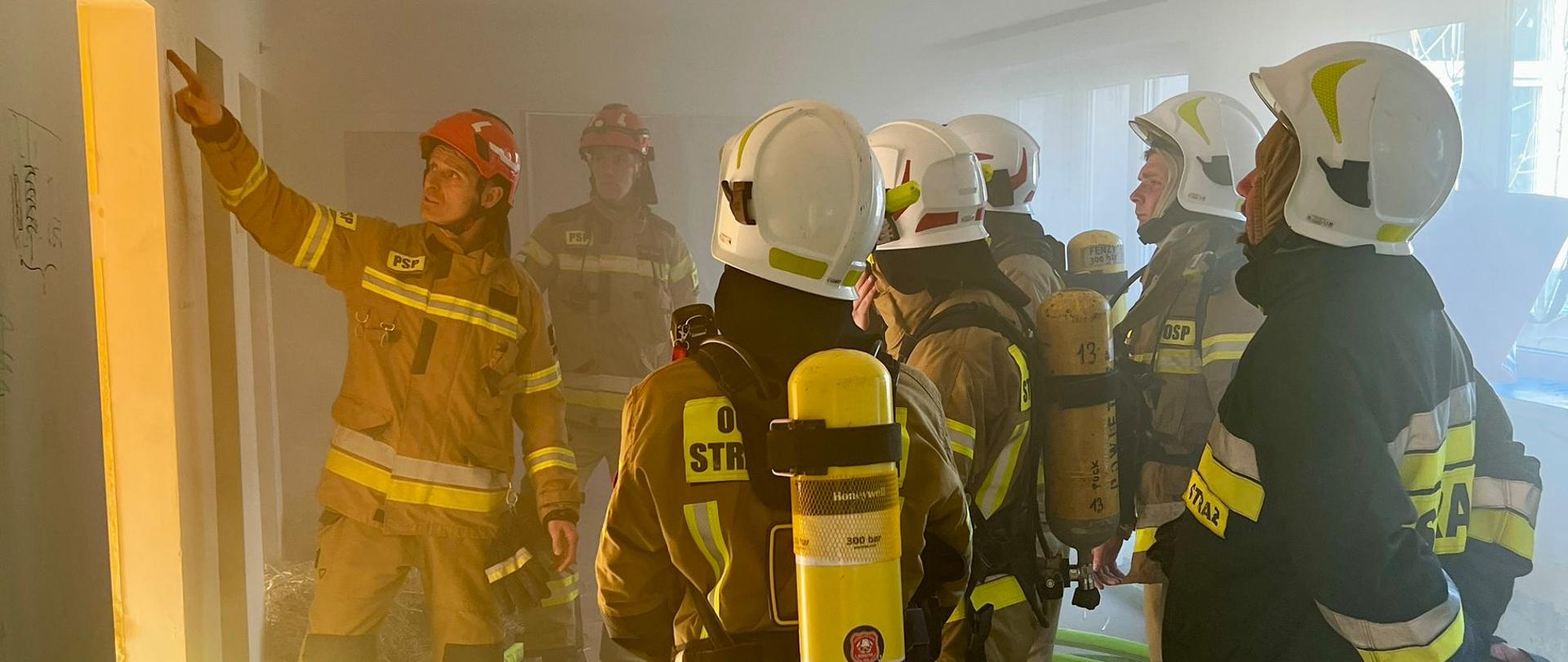 Na zdjęciu druhowie OSP ćwiczą siłowe otwieranie drzwi w warunkach pożarowych