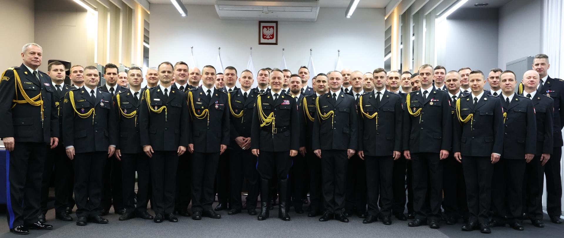 Grupowe zdjęcie strażaków z komendantem głównym PSP, wszyscy w mundurach galowych