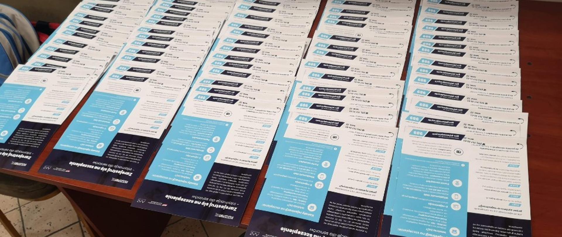 Zdjęcie przedstawia posegregowane właściwie do gmin ulotki na temat szczepień.