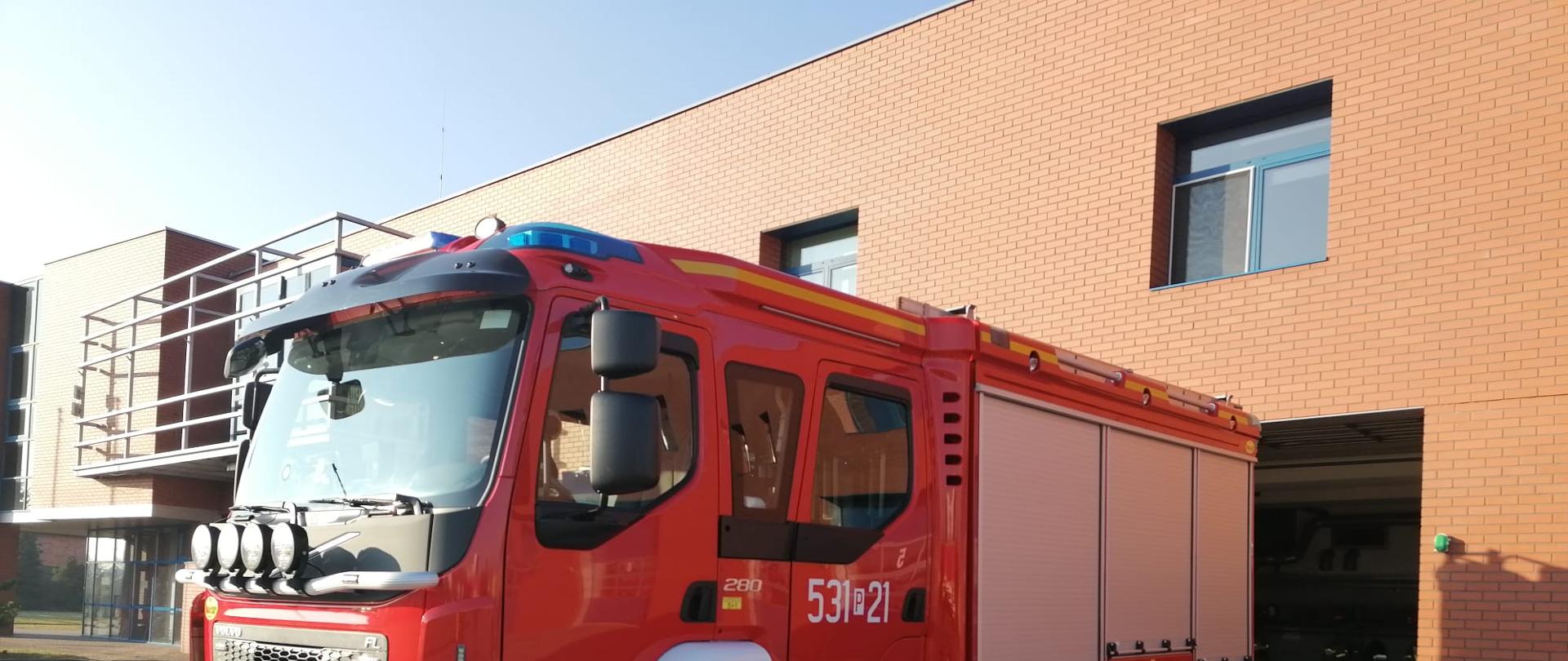 Nowy samochód ratowniczo-gaśniczy na tle Komendy Powiatowej PSP w Ostrowie Wielkopolskiej.