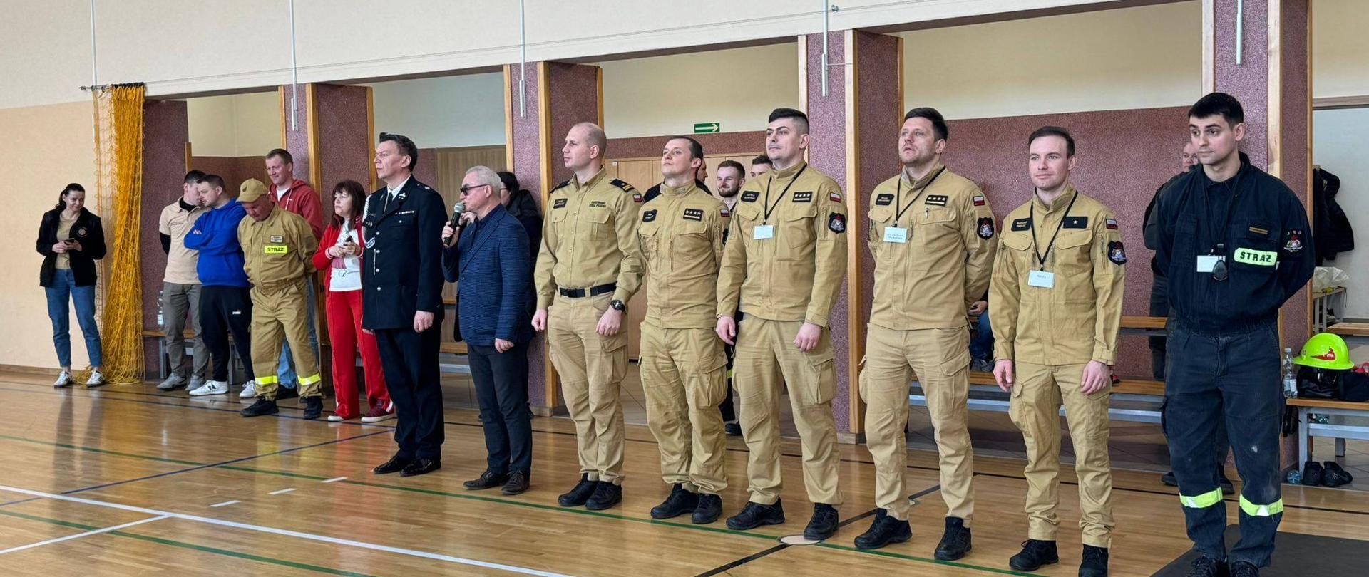 Zdjęcie przedstawia organizatorów zawodów, którzy stoją w jednym rzędzie. Z tyłu stoją opiekunowie uczestników.