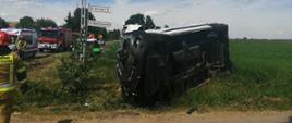 Na zdjęciu widoczny jest samochód dostawczy po zderzeniu z samochodem ciężarowym oraz Zespół Ratownictwa Medycznego i pojazd ratowniczo - gaśniczy.