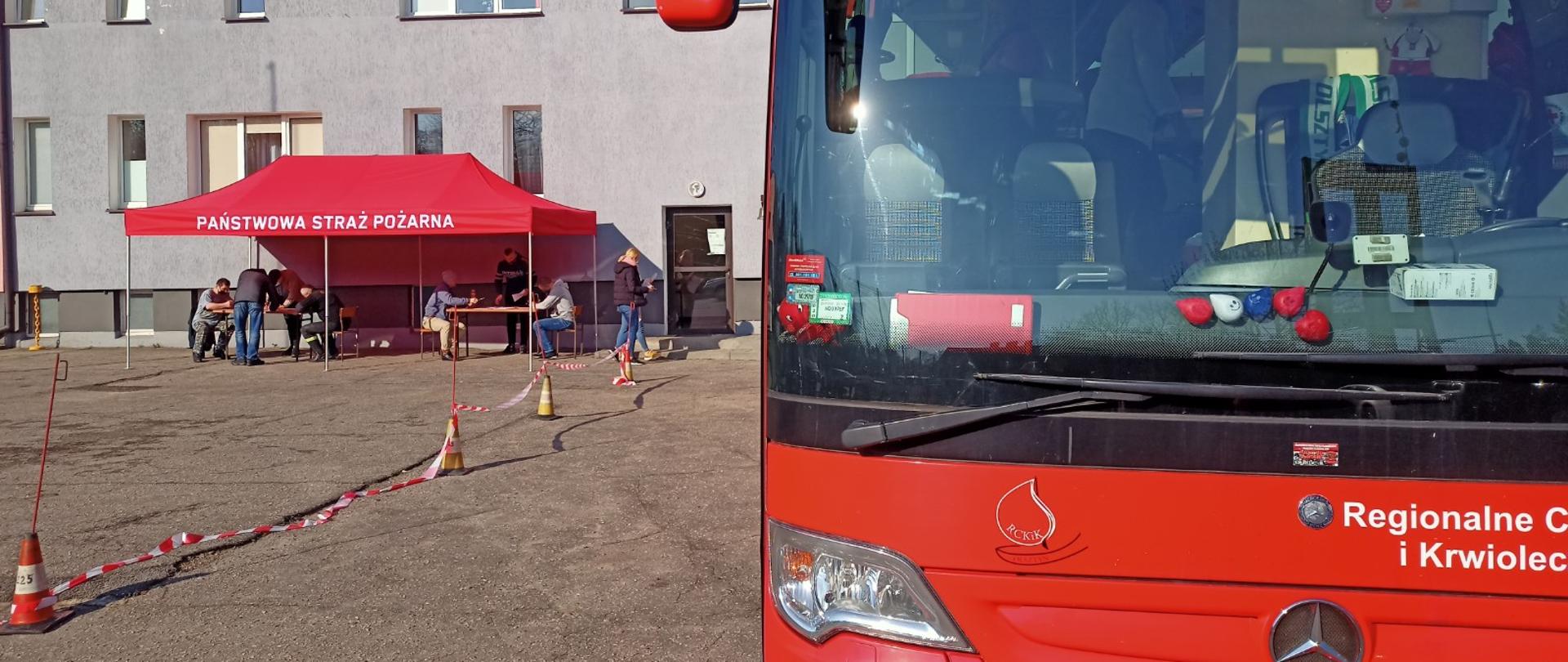 Zdjęcie przedstawia autobus RCKiK Olsztyn na tle budynku KP PSP Lidzbark Warmiński