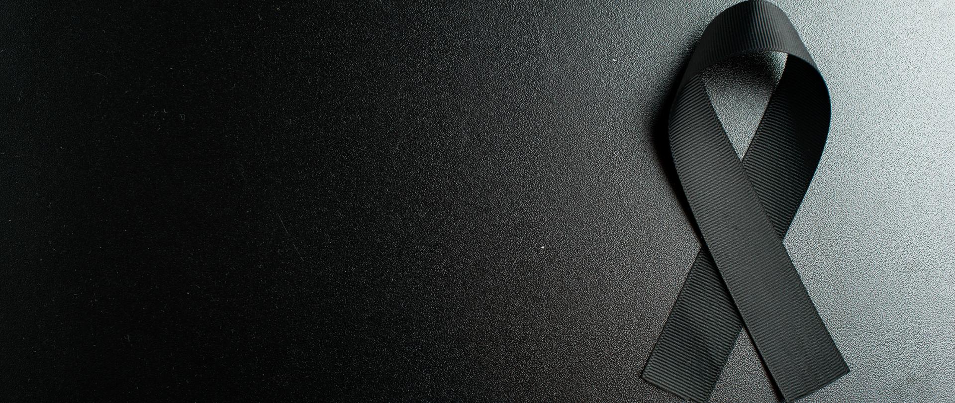 widok-z-gory-czarnej-kokardki-jako-symbolu-zaloby-na-ciemnej-scianie