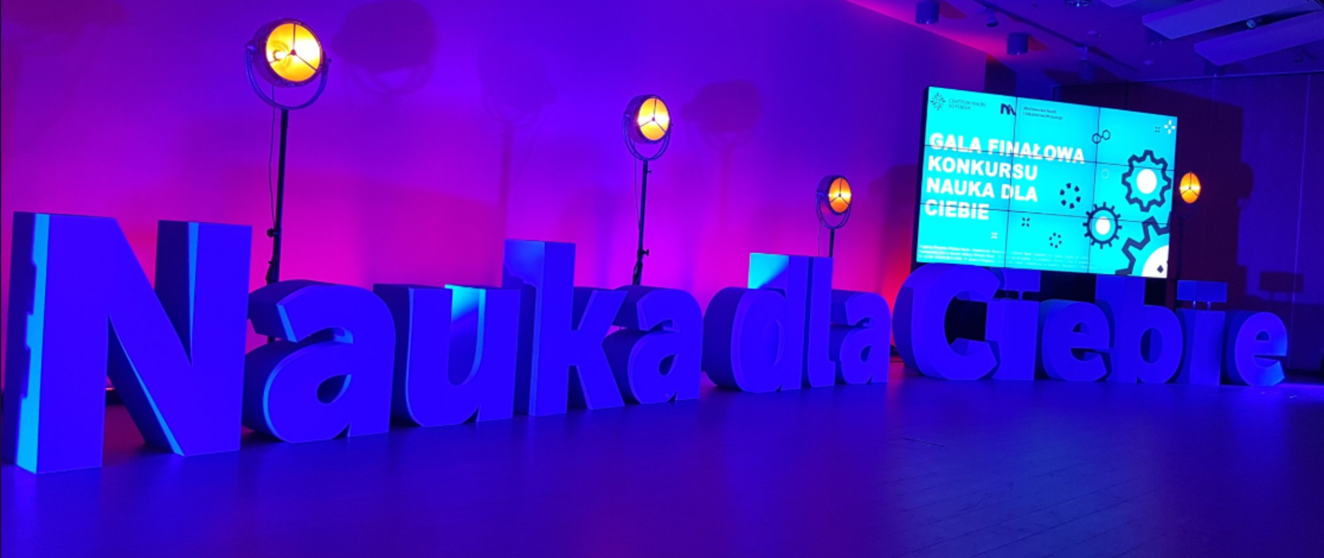 Na zdjęciu widać scenę podczas finałowej gali konkursu. Na scenie ustawione są litery, tworzące napis: Nauka dla Ciebie.