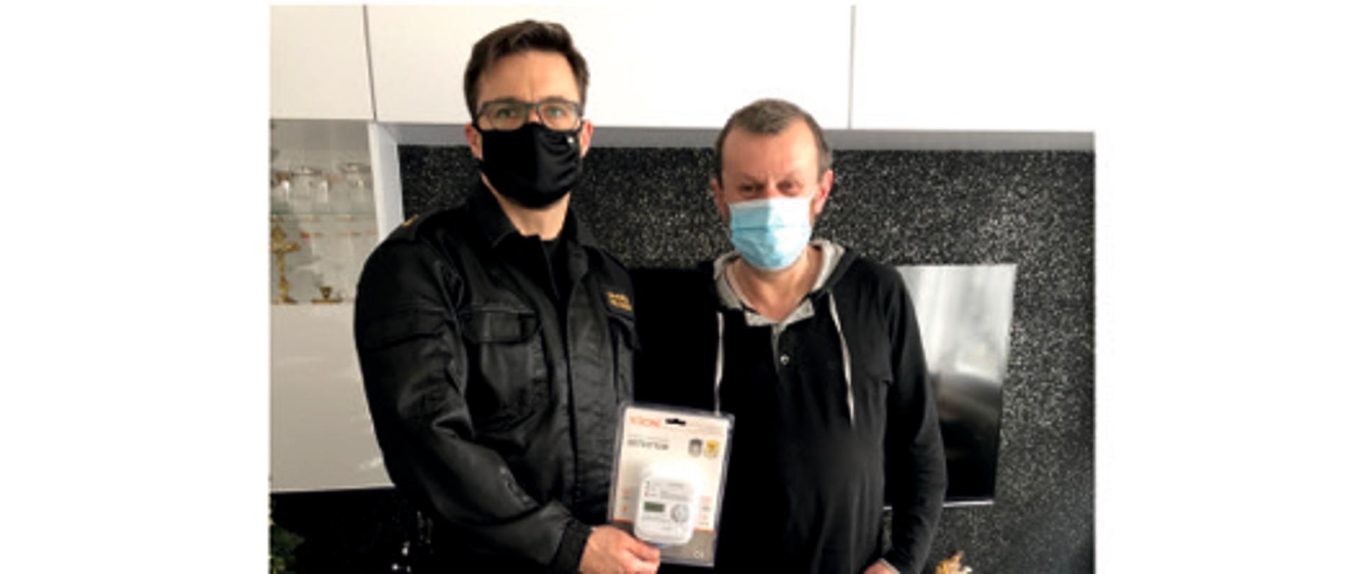 Przekazanie czujki tlenku węgla. Na zdjęciu obecną jest poszkodowana rodzina oraz funkcjonariusz PSP przekazujący czujkę. 