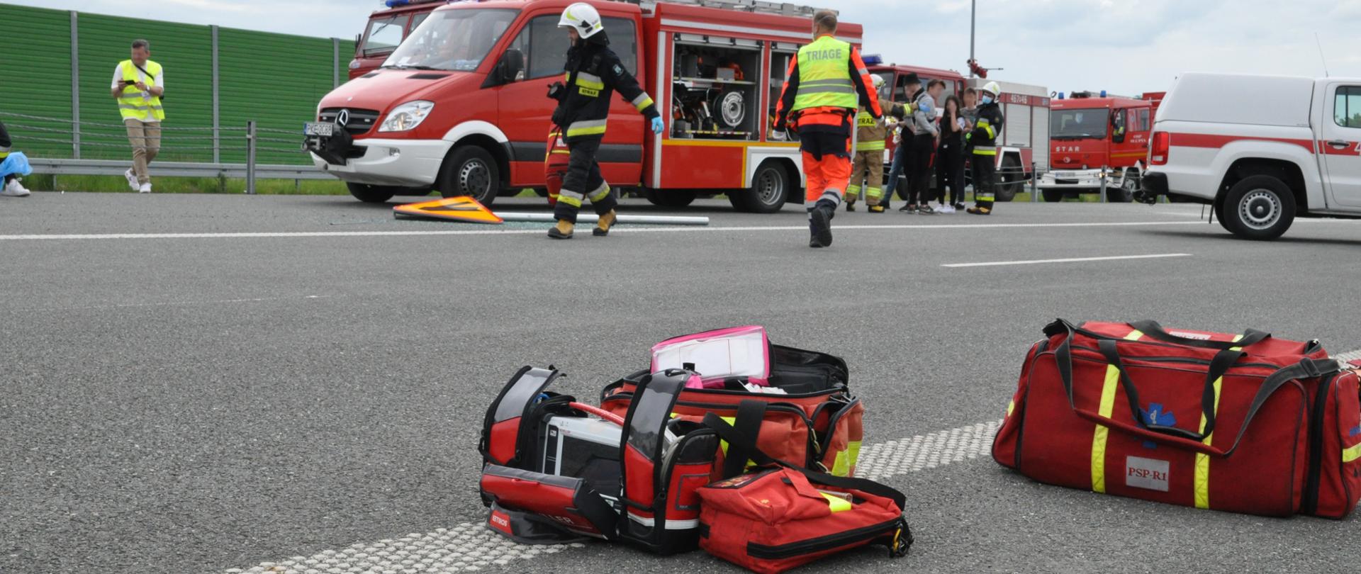 widoczne miejsce ćwiczeń pozoranci wraz z uszkodzonymi pojazdami, działające służby ratunkowe straż pożarna, pogotowie ratunkowe oraz policja.