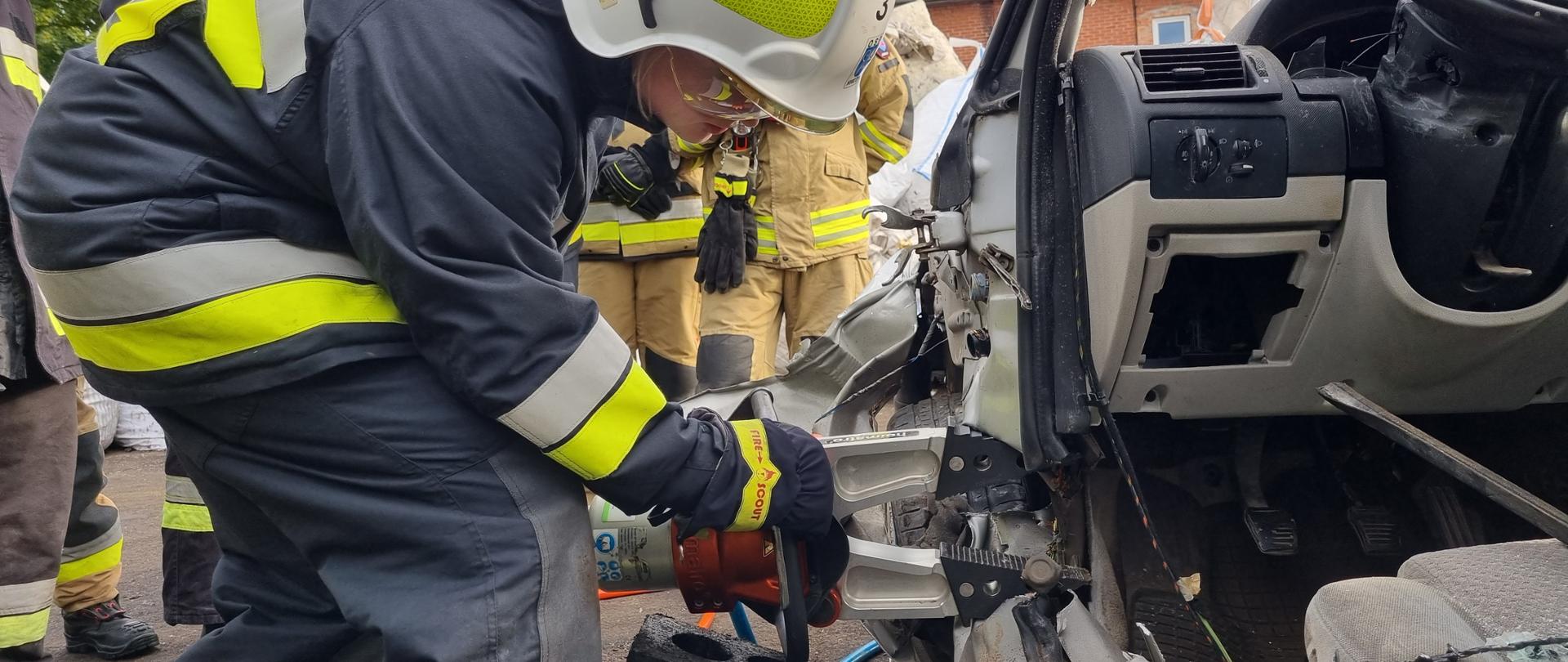 Strażak ćwiczy zastosowanie sprzętu hydraulicznego