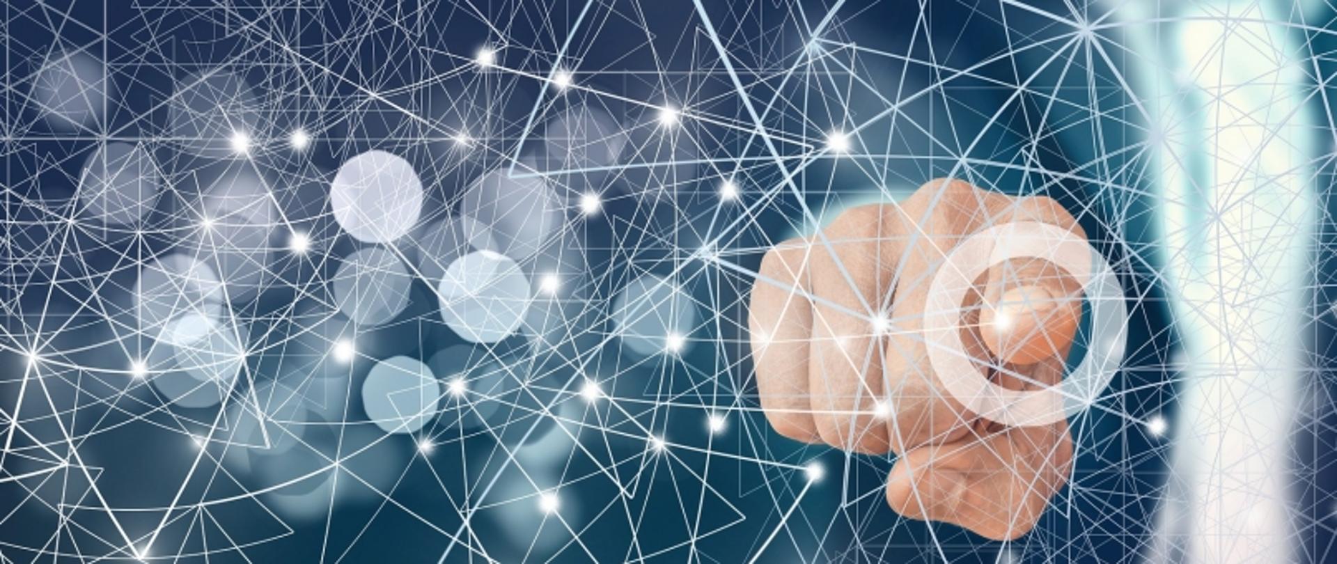 „Ręka wskazująca na futurystyczną sieć połączeń na ciemnym tle z efektem bokeh.”