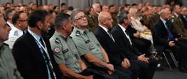 Sala konferencyjna. Dużo osób siedzi na krzesłach