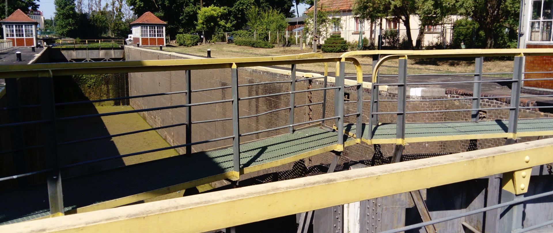 Śluza nr 4 drogi wodnej Wisła-Odra, która jest elementem międzynarodowej drogi wodnej E-70. Na pierwszym planie wrota śluzy, komora śluzy z opuszczoną wodą. Na drugim planie kładka na głowie górnej, która w czasie śluzowana chowa się pod wodę, natomiast kładka na głowie dolnej razem ze skrzydłami wrót rozchyla się na boki. 