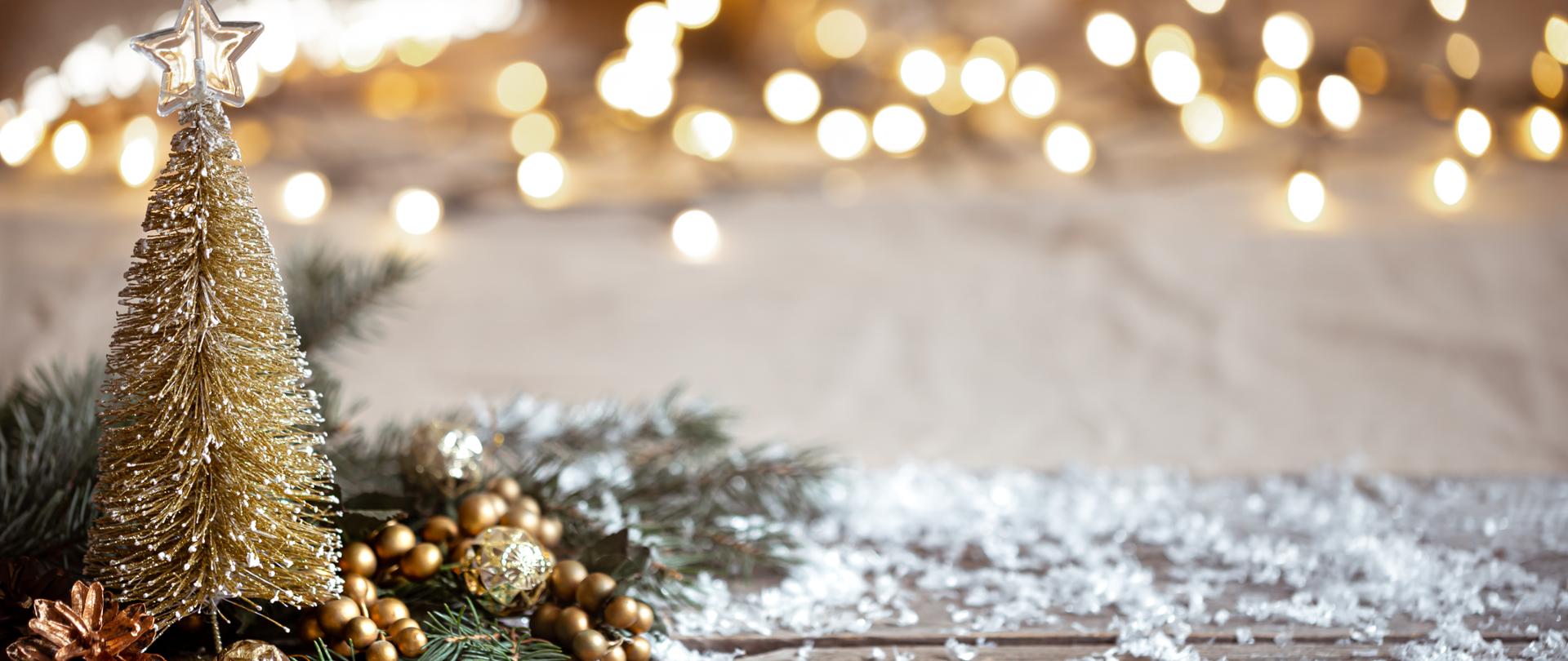 Winter cozy background with festive decor details, snow on a wooden table and bokeh. The concept of a festive atmosphere at home.