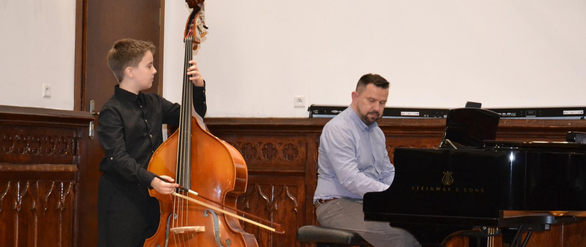 młody kontrabasista oraz nauczyciel pianista na scenie w sali królewskiej podczas koncertu muzyki kontrabasowej