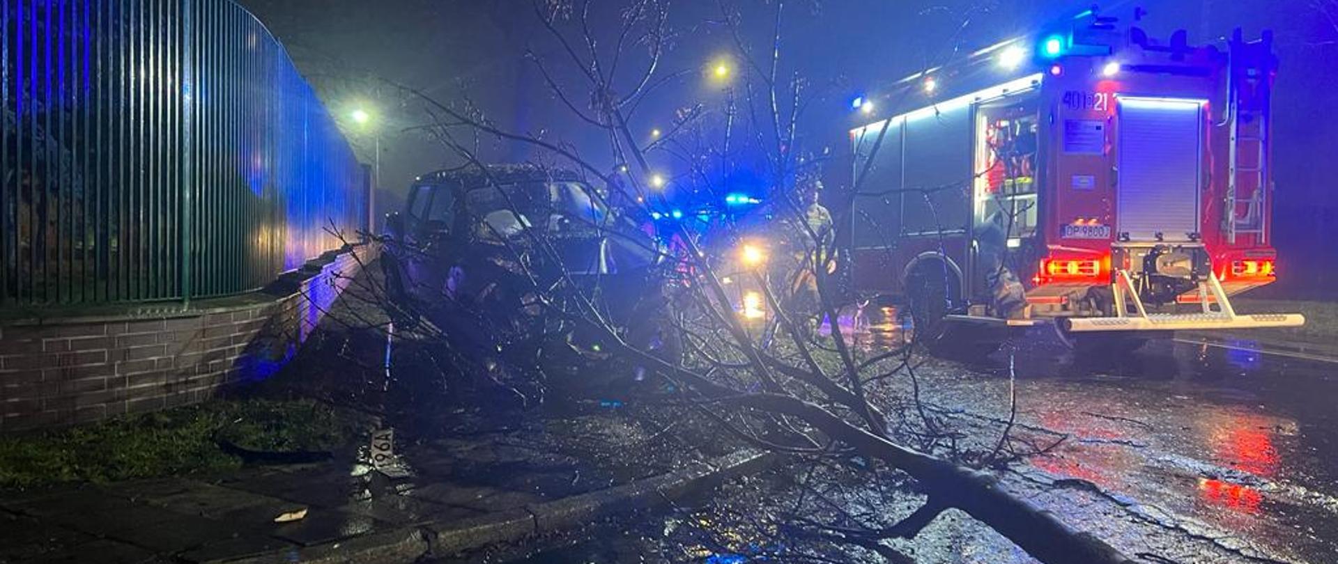 Wpadek śmiertelny z udziałem samochodu osobowego przy ul. Sikorskiego w Brzegu - zdjęcie przedstawia samochód osobowy przed którym znajduje się złamane drzewo w które uderzył samochód