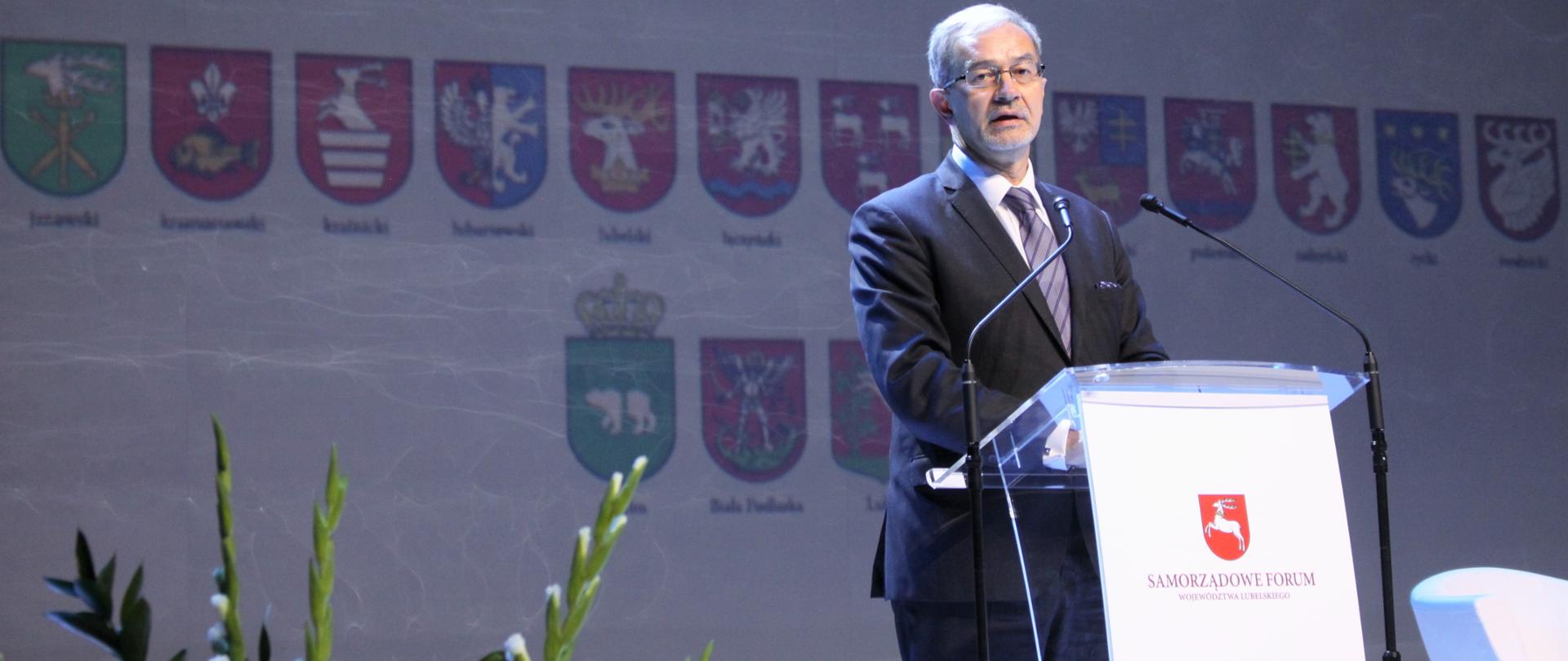 Minister Jerzy Kwieciński przed mikrofonami, za nim napis Samorządowe Forum Województwa Lubelskiego