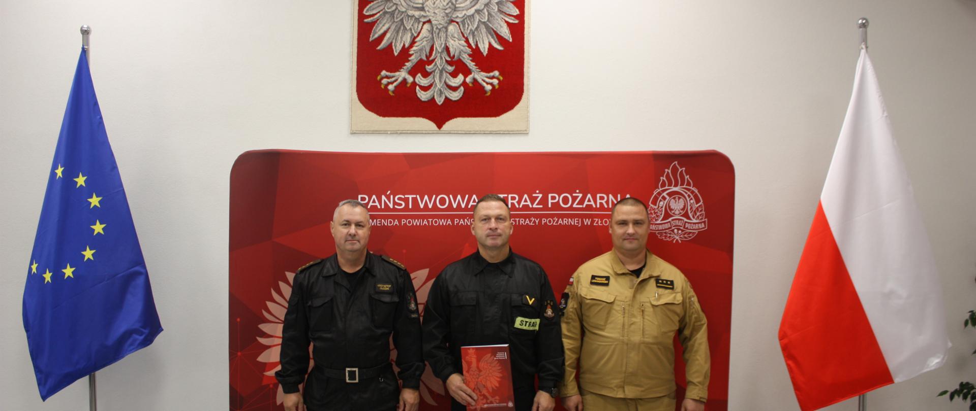 Strażacy na tle baneru straży