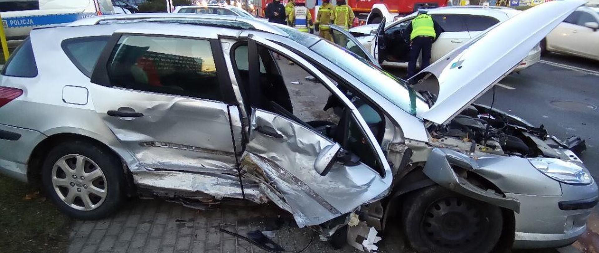 Zniszczony pojazd podczas wypadku, w tle wóz strażacki.