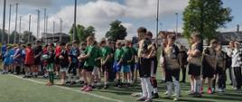 Drużyny piłkarskie stojące na boisku w szeregach przed turniejem