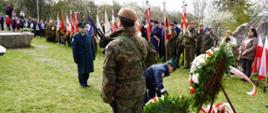 Funkcjonariusz składa wieniec pod pomnikiem