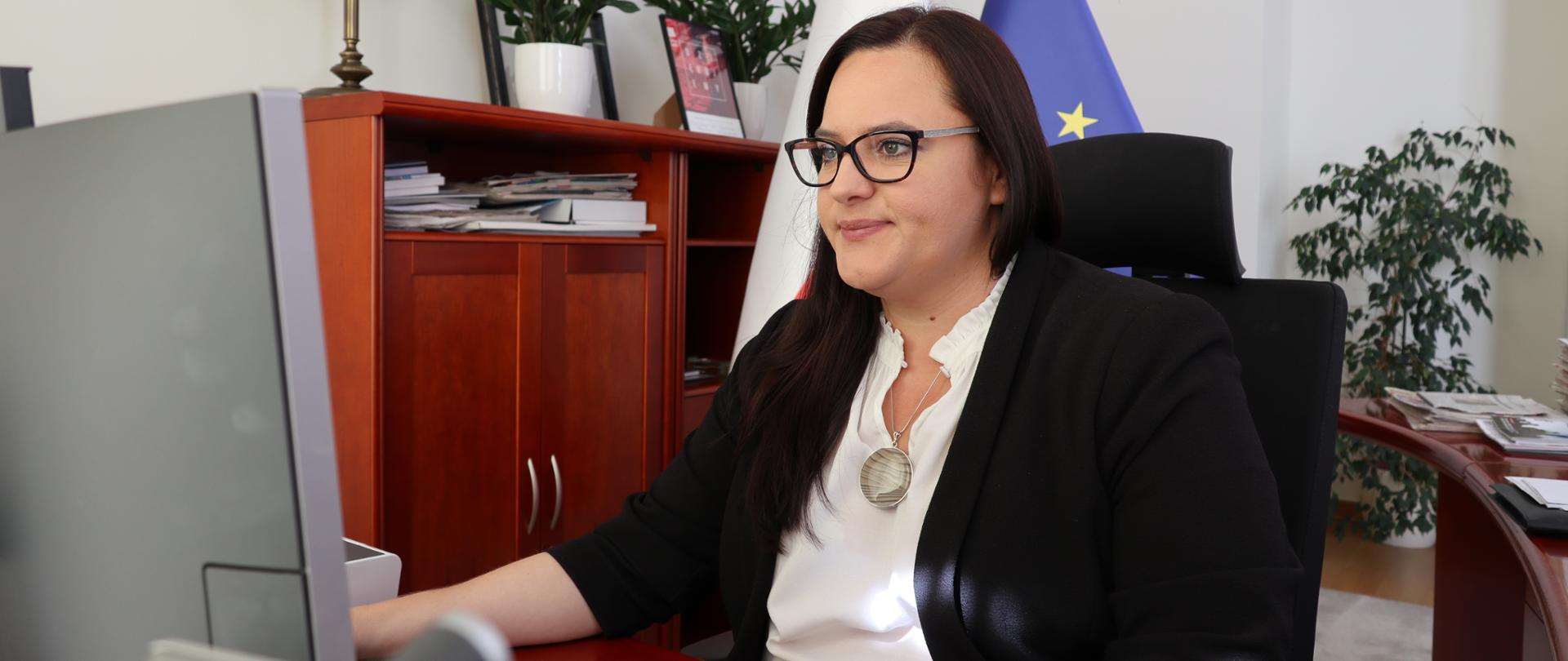 Małgorzata Jarosińska-Jedynak siedzi w gabinecie przy biurku przy komputerze.