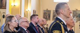 Zaproszeni goście w ławkach kościelnych podczas uroczystej mszy