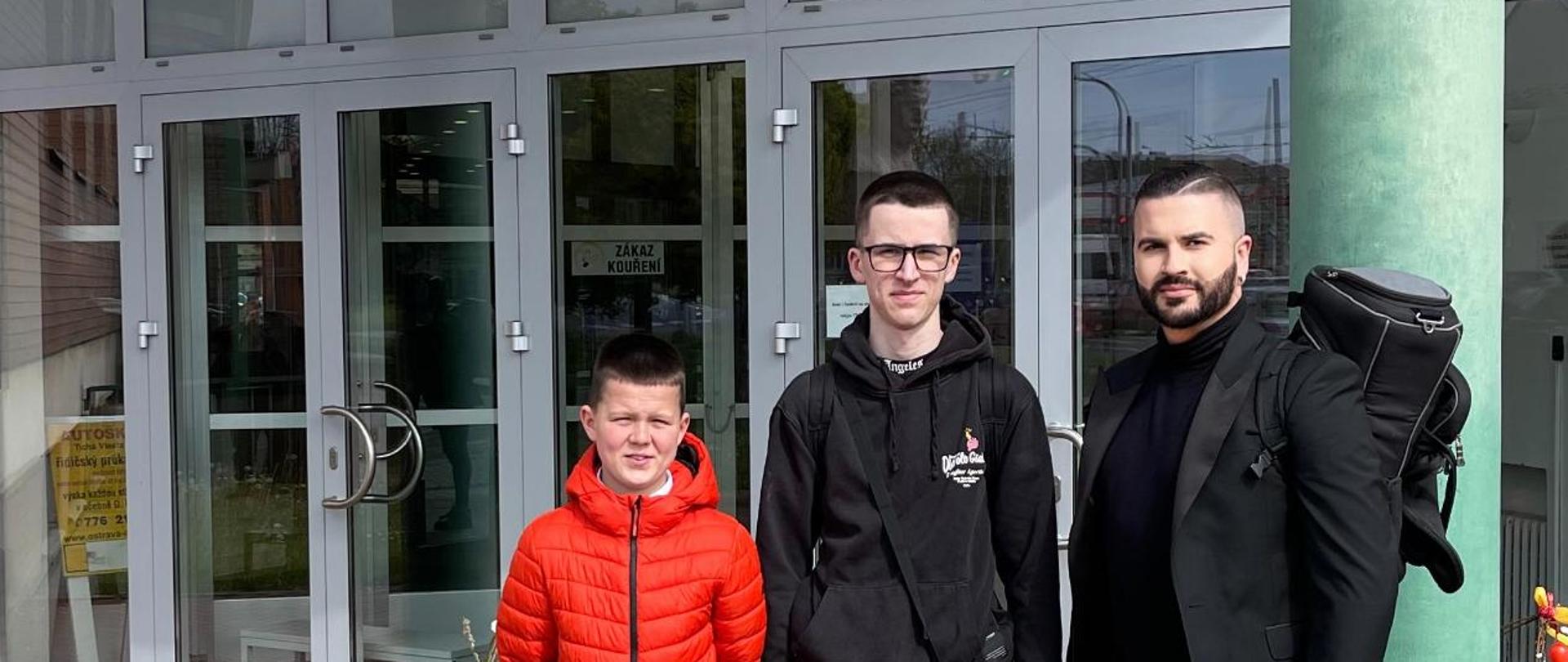 Zdjęcie na tle wejścia do holu sali, w której odbywały się przesłuchania konkursowe. Od lewej; Franciszek Brzózka, Franciszek Krygowski i ich nauczyciel mgr Wojciech Szela