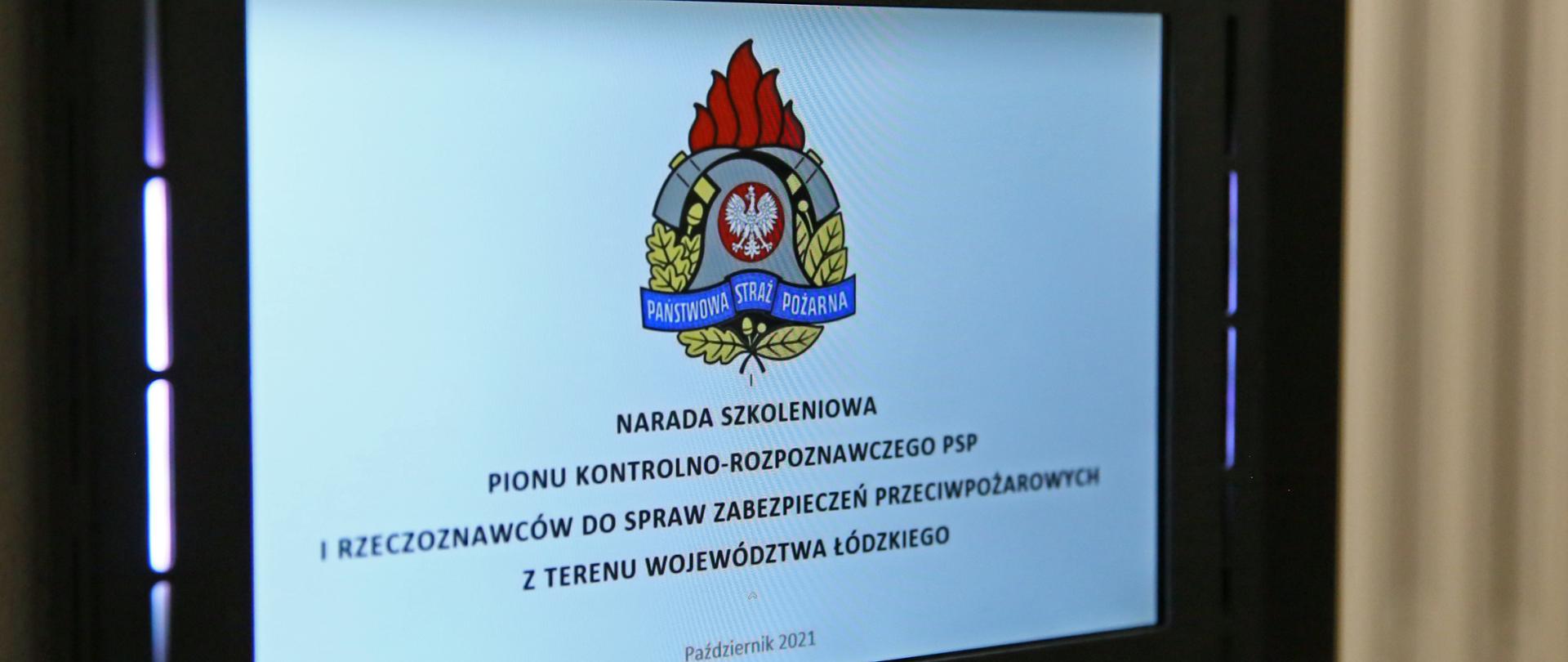 na zdjęciu ekran na ekranie logo PSP i napis: narada szkoleniowa pionu kontrolno-rozpoznawczego PSP i rzeczoznawców do spraw zabezpieczeń przeciwpożarowych z terenu województwa łódzkiego, październik 2021