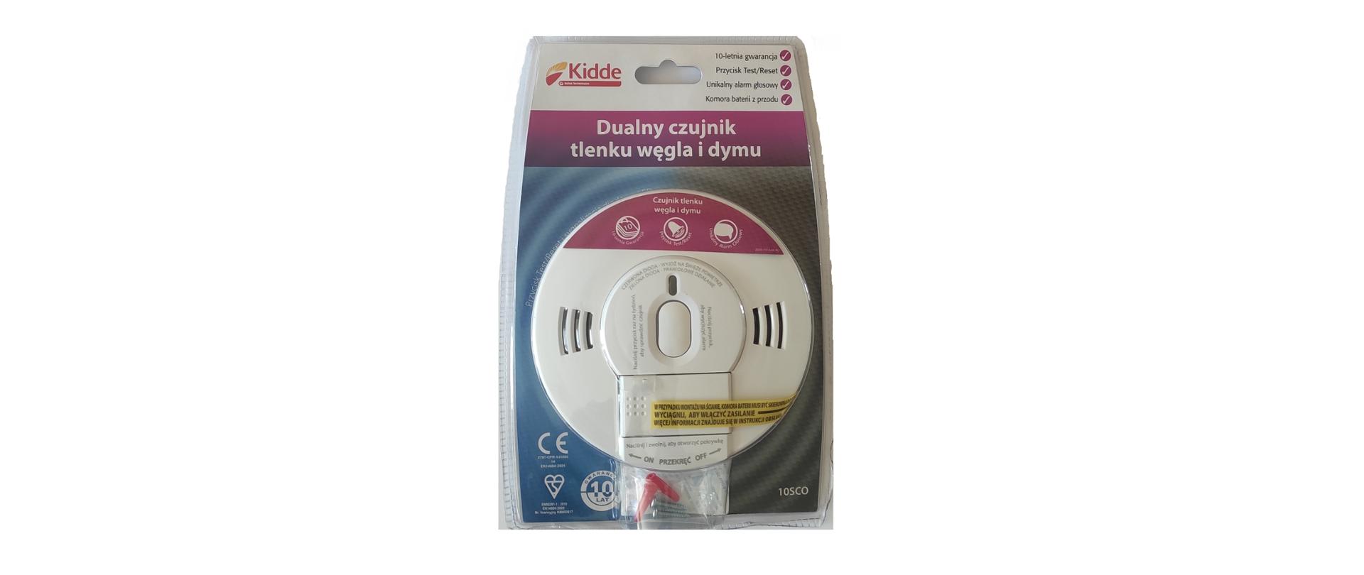 okrągła biała czujka w przeźroczystym plastikowym dopasowanym opakowaniu. na opakowaniu napis dualna czujka tlenku węgla i dymu