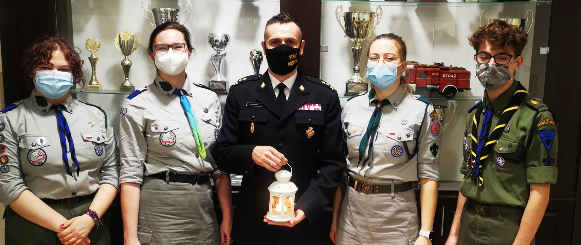 Harcerze przekazują betlejemskie światełko pokoju Komendantowi Miejskiemu PSP w Gdyni.