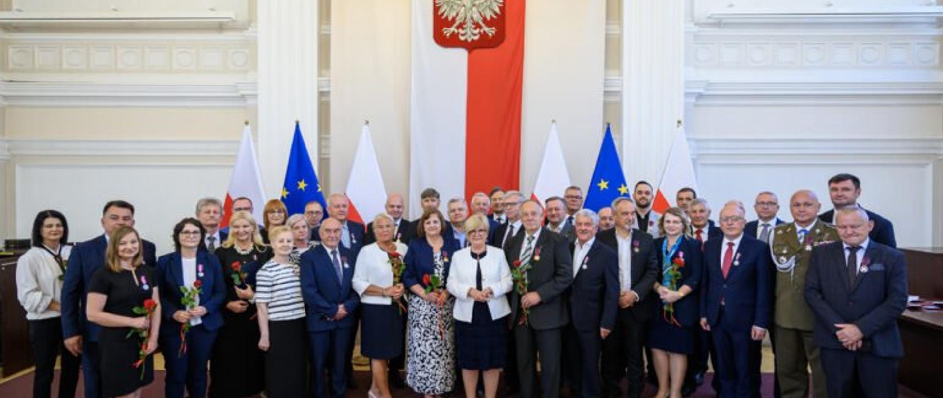 Zdjęcie przedstawia uczestników uroczystości wręczenia odznaczeń pańśtwowych