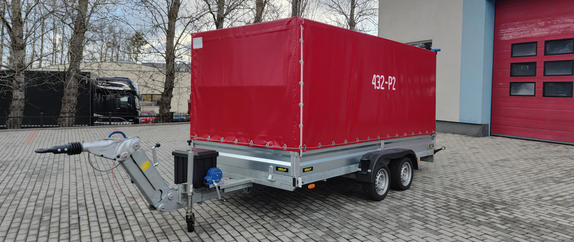 432 - P2 - Przyczepa ciężarowa. Przyczepka PSP z czerwoną plandeką. Stoi na placu wewnętrznym JRG na kostce brukowej.