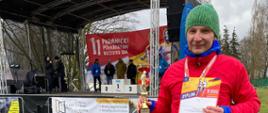 Na zdjęciu mł. ogn. Miłosz Michalak, który właśnie otrzymał pamiątkowy dyplom i puchar za zajęcie 3 miejsca w kategorii PSP w XI Pabianickim Półmaratonie. W tle scena z podium.
