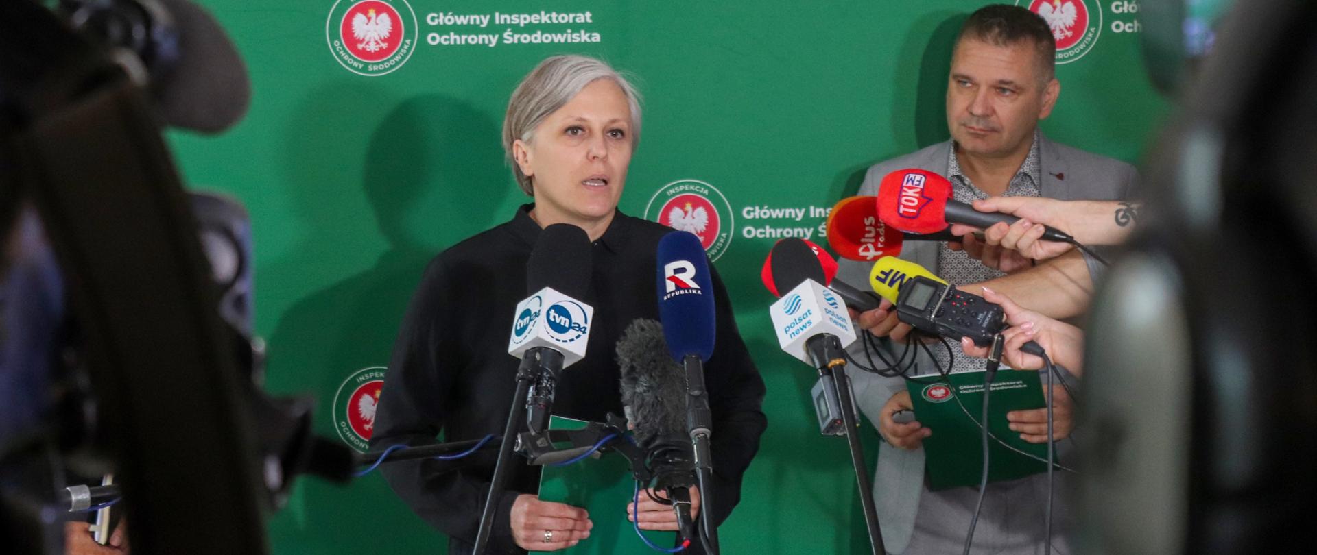 Kobieta mówiąca do wielu mikrofonów