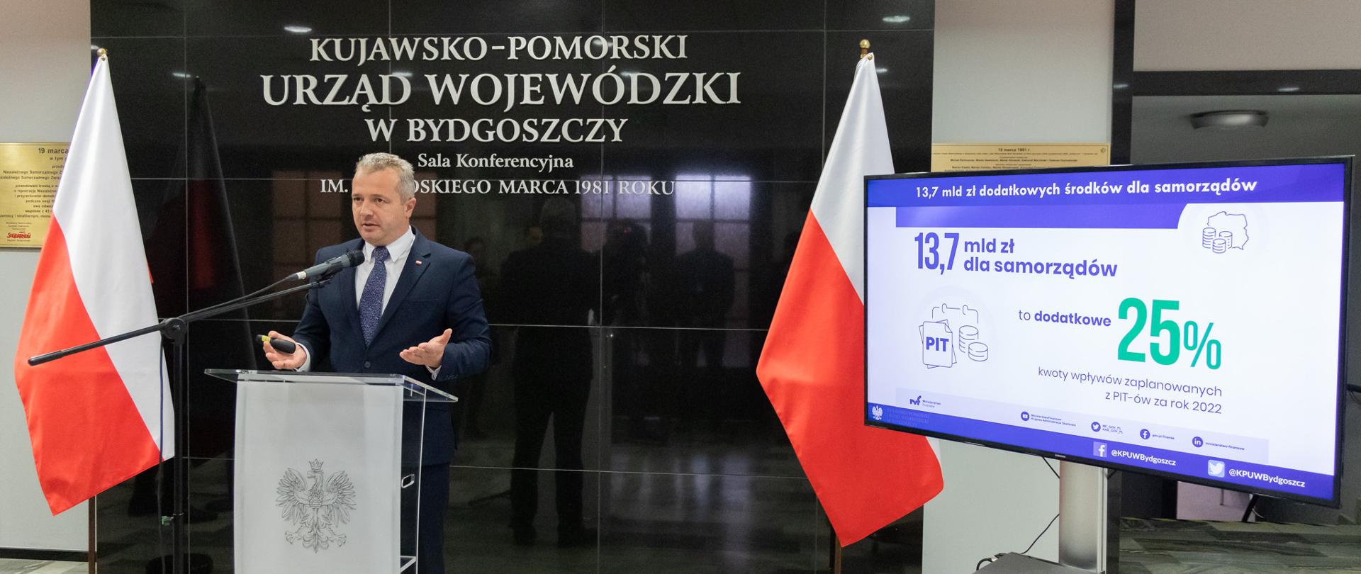 
Mężczyzna w garniturze stojący przy mikrofonie
