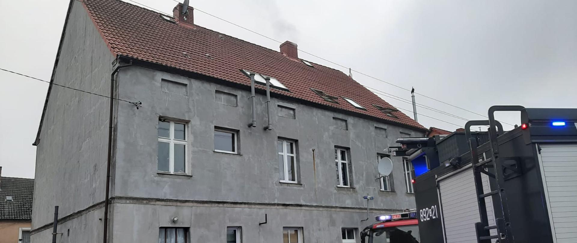 widoczne pojazdy gaśnicze na tle budynków mieszkalnych