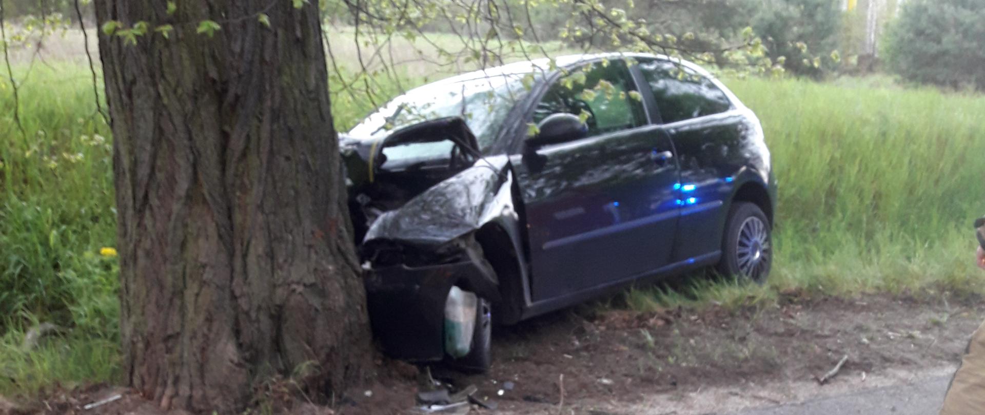 Uszkodzony pojazd stoi na poboczu przy drzewie