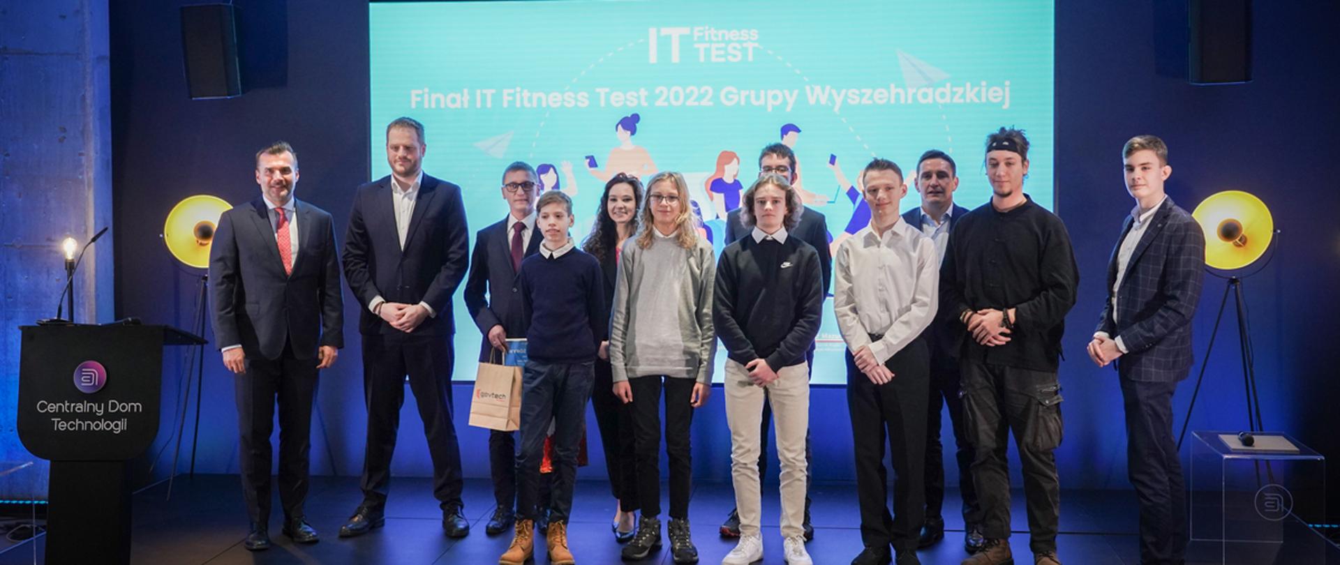 Grupa zwycięzców zdjęcie na tle diody z napisem IT Fitness Test 2022 Grupy Wyszehradzkiej